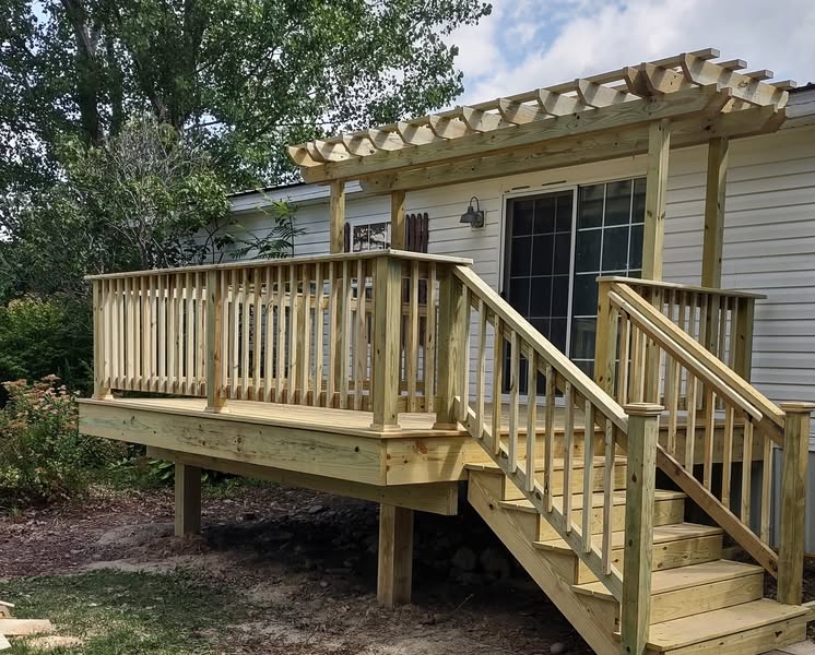 Finished pressure-treated deck addition with railings, stairs, and a pergola